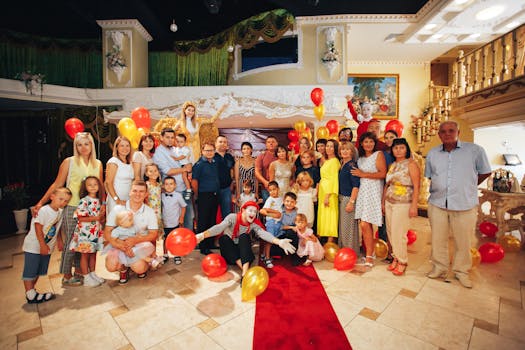 Group of people enjoying a festive indoor party with clowns and colorful balloons.