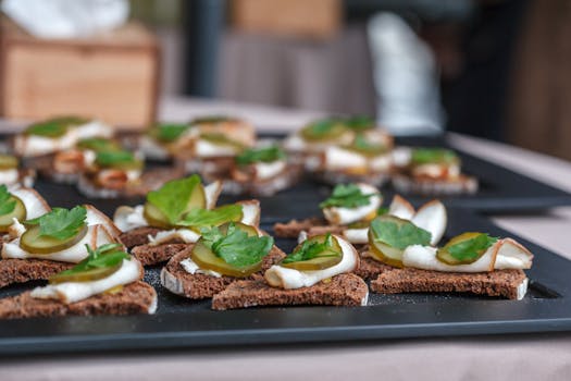 Delicious canapés with ham, pickles, and parsley on brown bread for a refreshing snack.