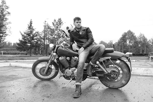 A stylish man in a leather jacket sitting on a classic motorcycle, exuding confidence.