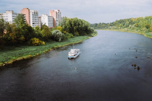 A scenic river cruise boat on the West Dvina surrounded by urban and natural landscapes in Vitebsk, Belarus.