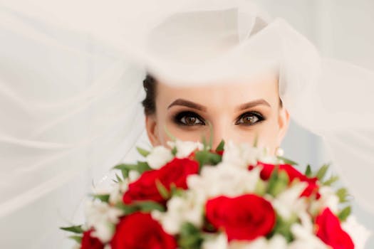 Bride's eyes over a vibrant bouquet, creating an intimate wedding moment.