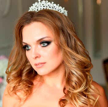 Portrait of a beautiful woman with golden hair wearing a tiara, captured indoors with soft lighting.