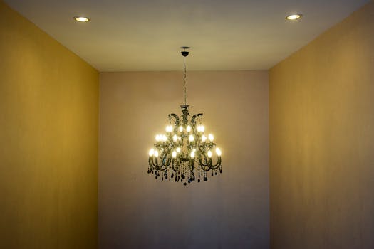 Luxurious crystal chandelier lighting up a hallway interior with warm ambiance.