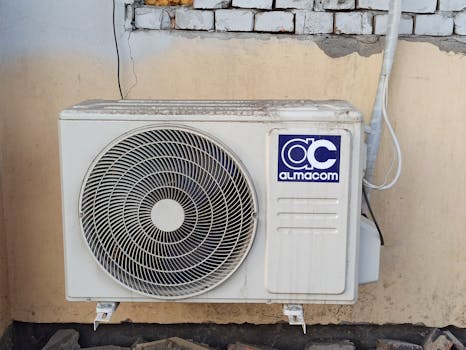 A well-used outdoor air conditioning unit affixed to a brick wall, showcasing urban climate control.