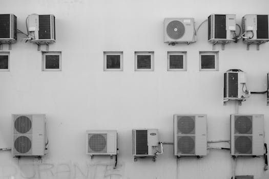 Black and white image of air conditioners mounted on a building facade in Córdoba, Argentina.