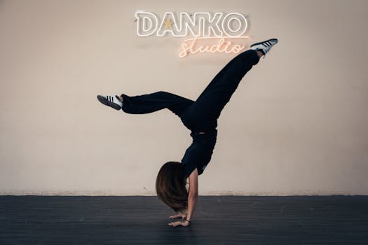Athletic young woman doing a handstand in Danko studio under neon lights.
