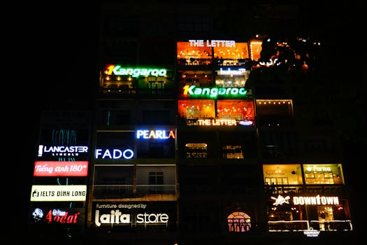 A vibrant night scene of a building facade with neon signs in Ho Chi Minh City, Vietnam.