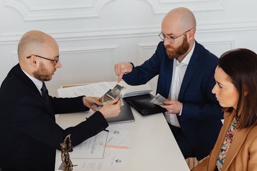 Lawyers meeting with a client discussing documents in a professional setting.